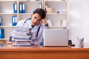Young handsome doctor working in the clinic 