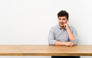 Young man with a table having doubts