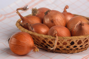 natural onions in a yellow husk in a basket close-up