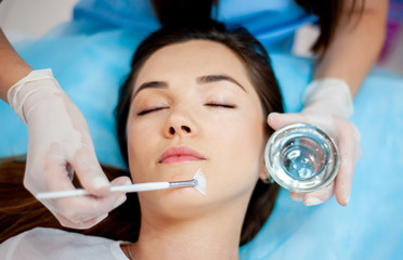Cosmetic procedure for the face. The procedure of applying the medicine on the face of a beautiful...