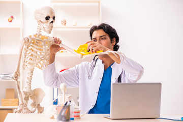 Young male doctor with skeleton 