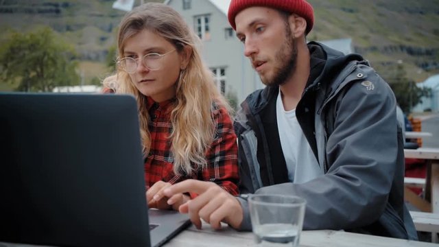 Interior designer or architect works in collaboration with website developer or client in laid back casual atmosphere, remotely from office on laptop, discuss and analize important startup project