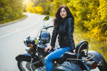 Foto op Plexiglas attractive brunette motorcyclist sits on a motorcycle. adventure concept © Dmytro Titov