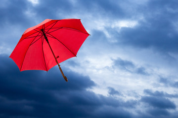 roter Regenschirn fliegt beim Sturm davon