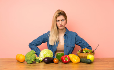 Fototapeta premium Young blonde woman with many vegetables angry