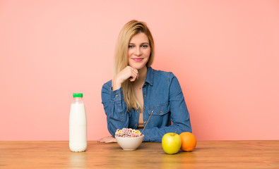 Young blonde woman with bowl of cereals laughing