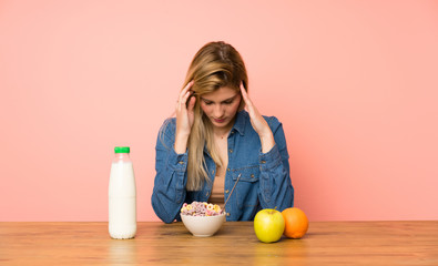 Young blonde woman with bowl of cereals unhappy and frustrated with something. Negative facial expression
