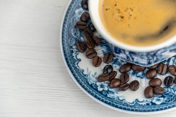 View from above of a delicious and tasty old and rustic cup of freshly made coffee with coffee beans
