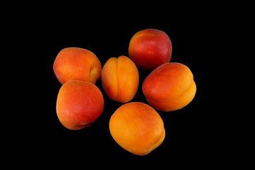 Ripe apricots on a black background close-up