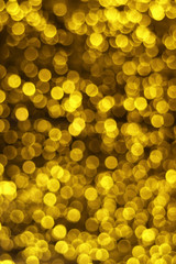 Vertical image of Defocused gold lights bokeh on dark background