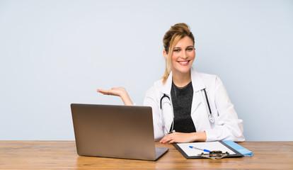 Blonde doctor woman holding copyspace imaginary on the palm to insert an ad