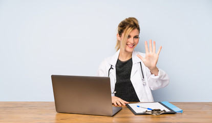 Blonde doctor woman counting five with fingers