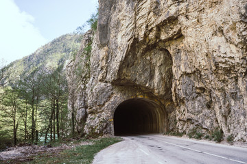 Road tunnel in rock mountains. Road and tunnel in mountain area. Narrow street in Durmitor National Park, Montenegro. Canyon