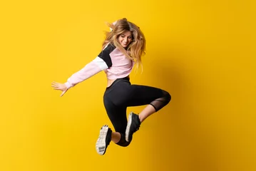 Fototapeten Urban Ballerina tanzt über isoliertem gelbem Hintergrund und springt © luismolinero