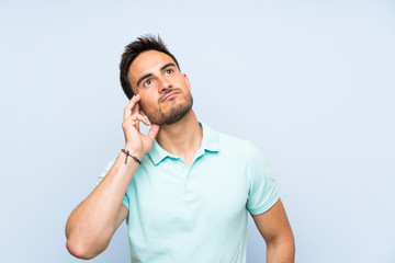 Handsome young man over isolated background thinking an idea