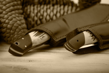 hunting knives and equipment photographed on a wooden surface, with hatches