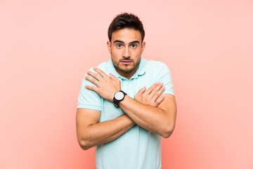 Handsome young man over isolated background freezing