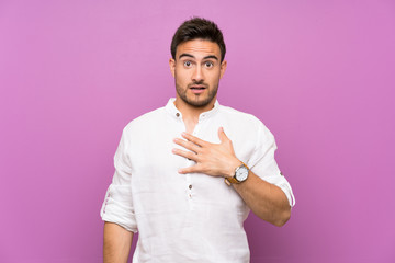 Handsome young man over isolated background surprised and shocked while looking right