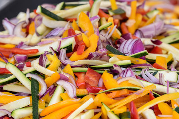 Close up of freshly cut organic vegetables, ready for cooking, pumpkin, onion, pepper, tomatoes