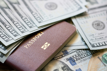 A large amount of 100 US dollar money notes on top of a stack of passports, travel and business trip concept © tatomm