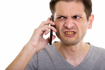 Close up of angry young man talking on mobile phone