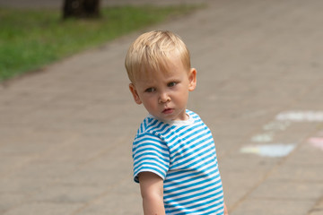Sad boy with striped t-shirt outside