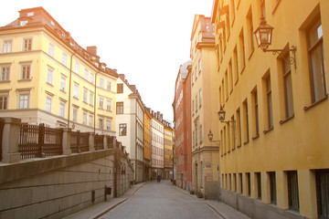 Fototapeta na wymiar Deserted pedestrian street in the old part of Stockholm, Sweden. Colorful houses with vintage lanterns.