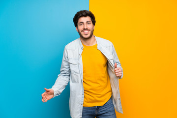 Handsome over isolated colorful background smiling