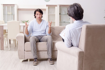 Young male patient discussing with psychologist personal problem