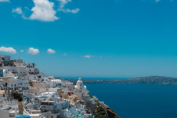 Santorini, Greece. Picturesque view of traditional cycladic Santorini houses on small street with flowers in foreground. Location: Oia village, Santorini, Greece. Vacations background.
