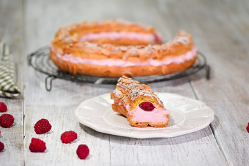 Homemade choux pastry cake Paris Brest with raspberries, almond, sugar powder. French dessert