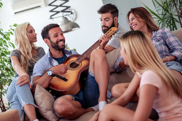 Group of friends have fun with guitar