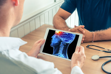 Doctor holding a digital tablet with x-ray of the 3D head of the patient with pain on the front of...