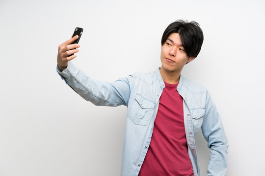 Asian man on isolated white background making a selfie