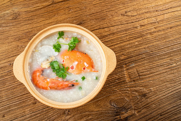 a pot of seafood porridge on the wooden table, Chinese Chaoshan casserole porridge