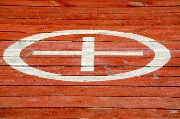 on the red flooring of the boards painted circle and a cross in it - 270946113