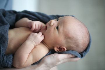 Newborn baby in mom's hands,top view. Casual style
