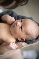 Newborn baby in mom's hands,top view. Casual style