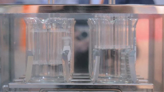 Pharmaceutical testing laboratory equipment - automatic tablet disintegration and dissolution apparatus with two basket at pharmacy factory or exhibition. Pharma industry, medicine and science concept