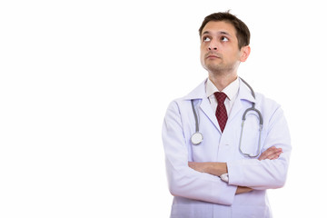 Studio shot of young man doctor thinking while looking up with a