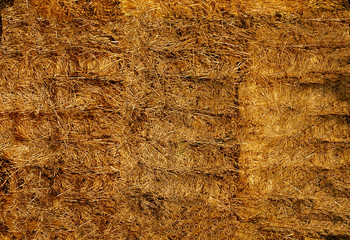 Straw in huge square bales lying on top of each other .Texture or background.