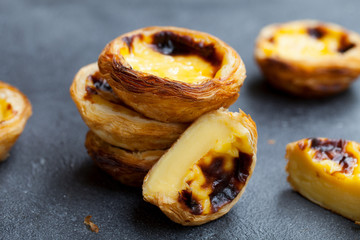Egg tart, traditional Portuguese dessert, pastel de nata. Slate background. Close up.