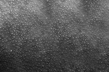 Matte artificial leather of dark color with pimples on the surface.Texture or background.