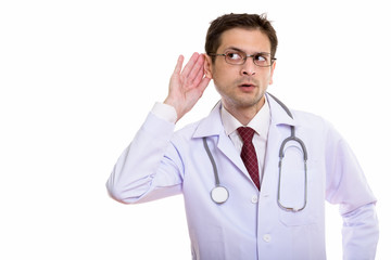 Studio shot of young man doctor wearing eyeglasses while listeni
