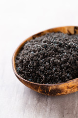 Sea salt in bowl, aroma oil in bottles, Wellness and flowers on grey textured background and flowers on vintage wooden background. Selective focus.