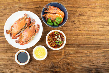 A dish of steamed three-pointed crab and sauce on a wooden table