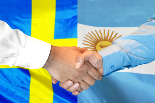 Business handshake on the background of two flags. Men handshake on the background of the Argentina and Sweden flag. Support concept