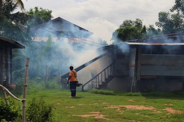 Employees are using fogging machines to get rid of mosquitoes to prevent dengue fever, take blurred pictures