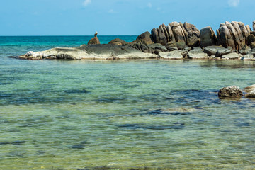 The background of a large rocky island in the blue sea and a blue sky