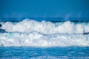 Beautiful Tropical Island Paradise Photo of Clear Aqua Blue Ocean Wave Crashing on Rocks with Sun Rays Coming Though Clouds of Colorful Pastel Sunset Sky at Dusk on Maui Hawaii